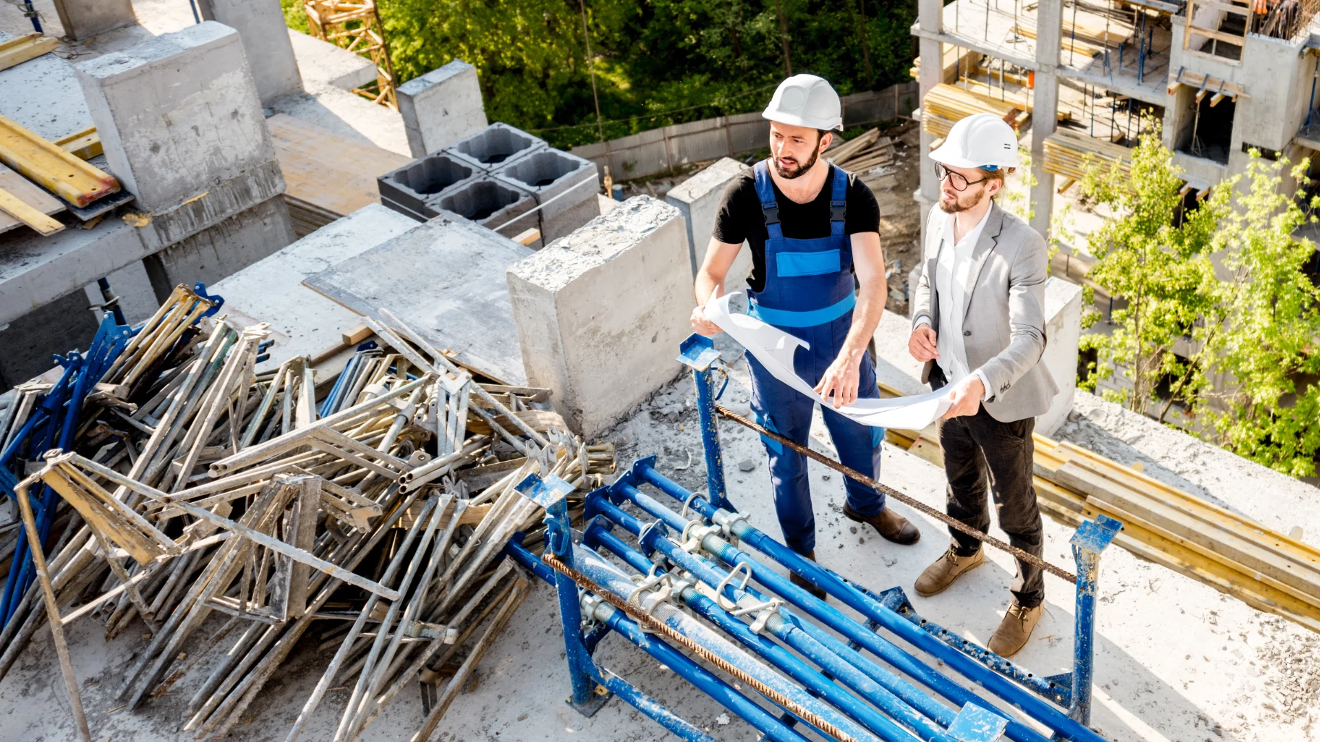 Bauarbeiter prüfen Pläne auf Baustelle im Freien