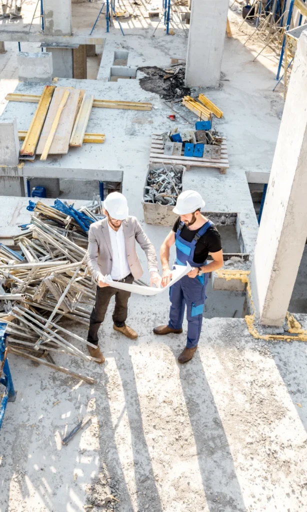 Bauarbeiter prüfen Baupläne auf Baustelle