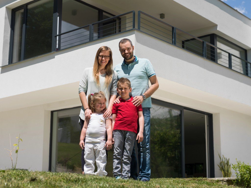 Eien vierköpfige Familie vor ihrem Haus
