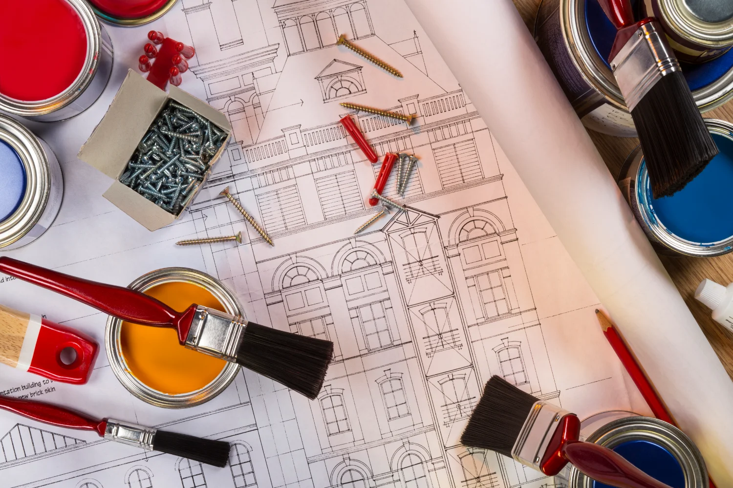 Architekturplan mit Farbdosen, Pinseln und Schrauben