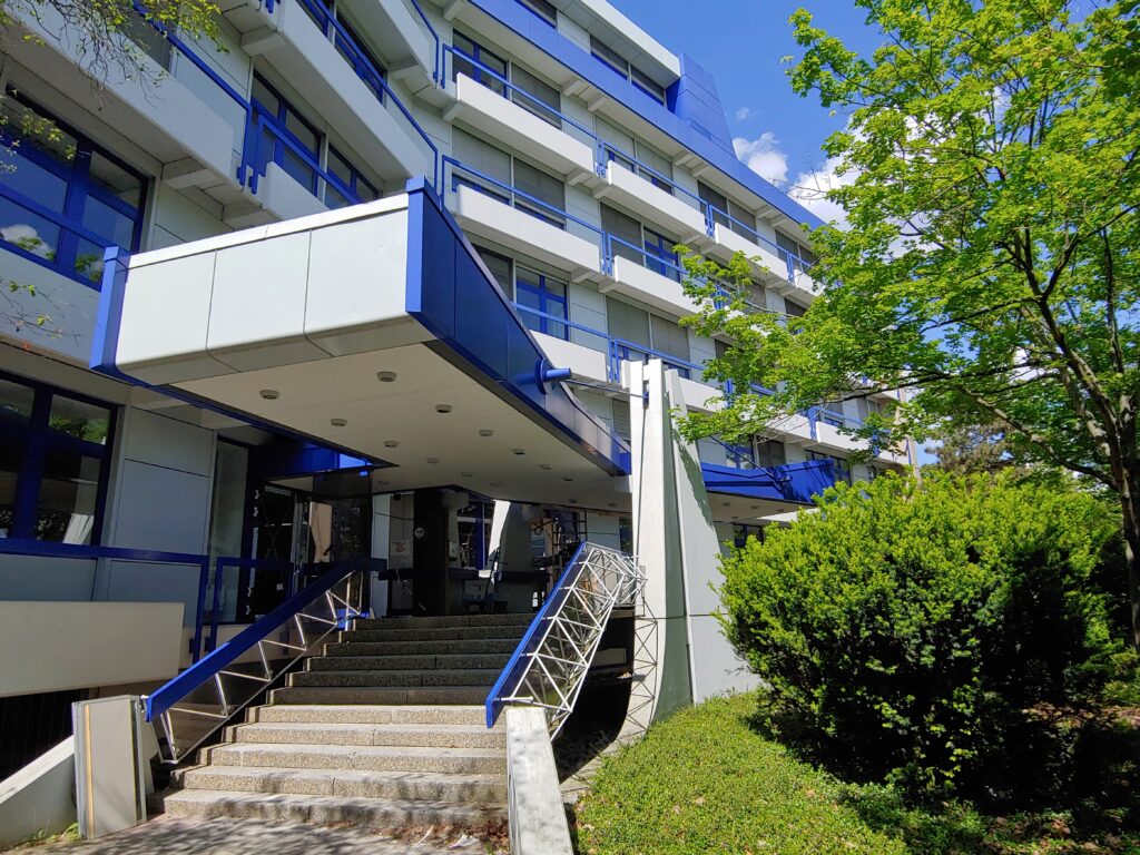 Modernes Bürogebäude mit blauer Fassade und Eingangsbereich