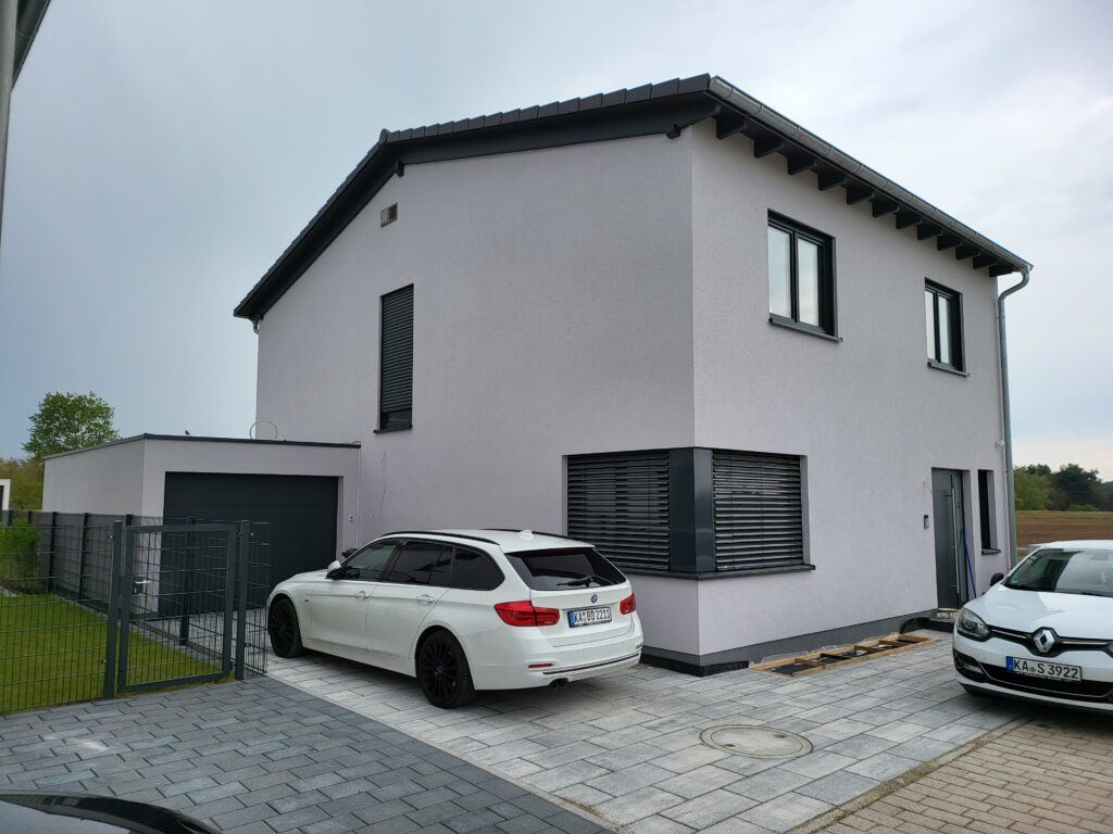 Modernes Einfamilienhaus mit zwei geparkten Autos