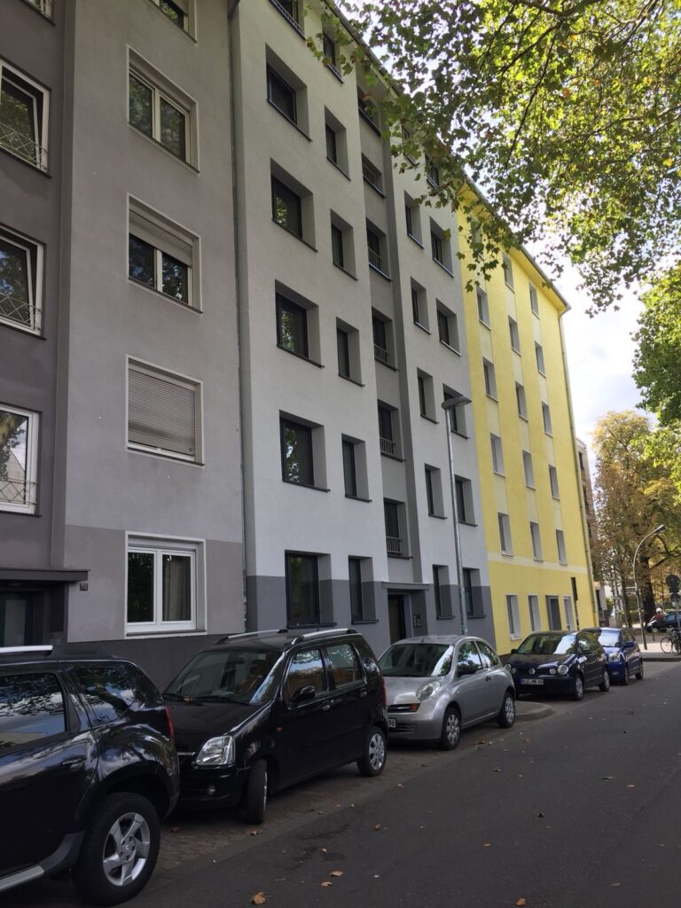 Wohngebäude mit parkenden Autos auf Stadtstraße