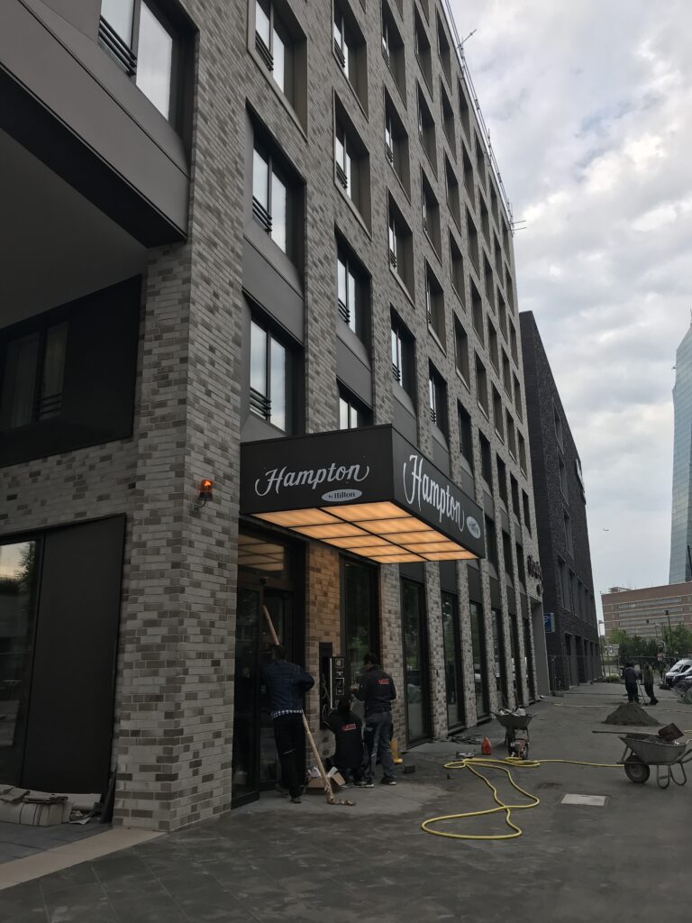 Arbeiter vor dem Hotel Hampton by Hilton Gebäude