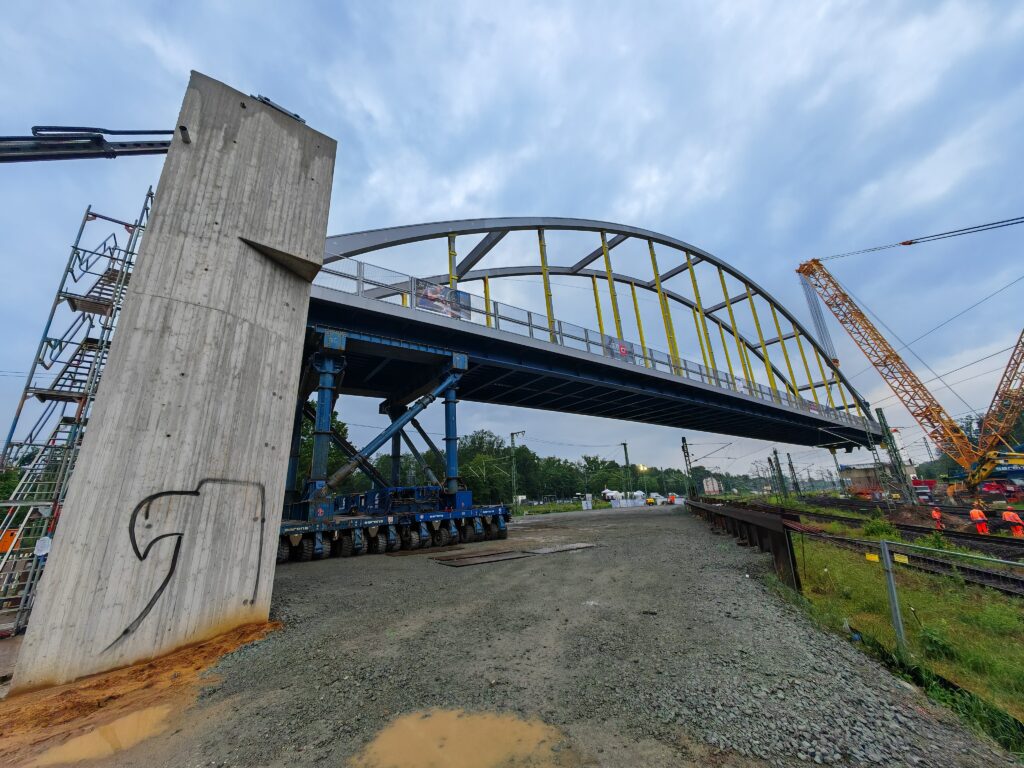 Neue Stahlbogenbrücke über Bahngleise bei Bauarbeiten